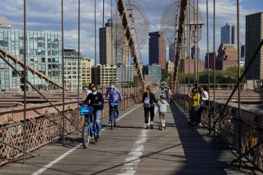 NEW YORK - 4 Mayıs 2020: New York 'taki koronavirüs (COVID-19) salgını sırasında Brooklyn Köprüsü' nden geçen bisikletçiler ve yayalar. Her gün yaklaşık 4 bin yaya ve 2 bin 600 bisikletçi köprüden geçiyor.