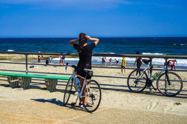 FAR ROCKAway, New York - 15 Mayıs 2020: Bisikletçiler Far Rockaway, New York 'taki Riis Park Tahta Yolu' nda COVID-19 pandemisi sırasında açık havanın tadını çıkarıyorlar