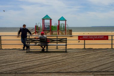 BROOKLYN, NEW YORK - 20 Mayıs 2020: New York Şehir Parkları Departmanı tarafından imzalanan imza, Coney Island Sahili Riegelmann kaldırımında sosyal mesafenin 1.80 metre olduğunu gösteriyor.