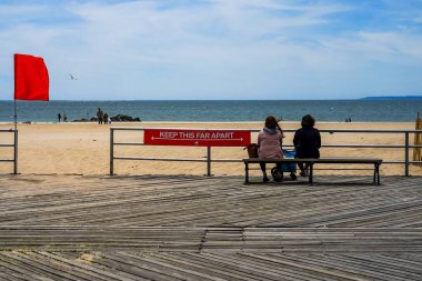 BROOKLYN, NEW YORK - 20 Mayıs 2020: New York Şehir Parkları Departmanı tarafından imzalanan imza, Coney Island Sahili Riegelmann kaldırımında sosyal mesafenin 1.80 metre olduğunu gösteriyor.