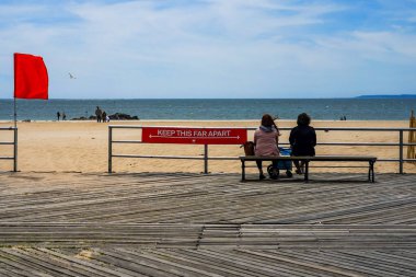 BROOKLYN, NEW YORK - MAY 20, 2020: Sign by the New York City Parks Department indicates the appropriate measurement for social distancing of six feet on the Riegelmann boardwalk at Coney Island Beach clipart