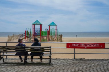 BROOKLYN, NEW YORK - 20 Mayıs 2020: New York Şehir Parkları Departmanı tarafından imzalanan imza, Coney Island Sahili Riegelmann kaldırımında sosyal mesafenin 1.80 metre olduğunu gösteriyor.