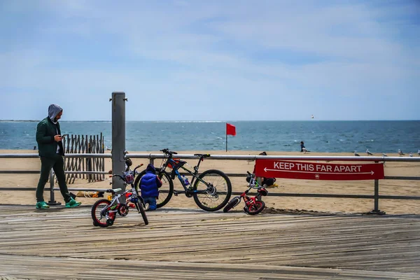 BROOKLYN, NEW YORK - 20 Mayıs 2020: New York Şehir Parkları Departmanı tarafından imzalanan imza, Coney Island Sahili Riegelmann kaldırımında sosyal mesafenin 1.80 metre olduğunu gösteriyor.