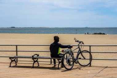 BrooKLYN, NEW YORK - 20 Mayıs 2020: Yayalar ve bisikletçiler, New York, Brooklyn 'deki Coney Island Beach' teki Riegelmann tahta yolunda COVID-19 salgını sırasında açık havanın tadını çıkarıyorlar. 