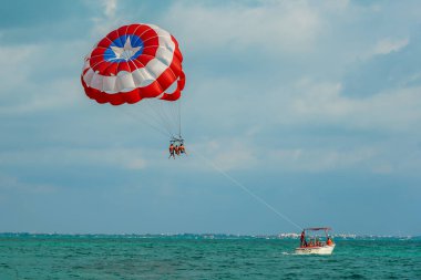 CANCUN, MEXICO - 2 HAZİRAN 2020: Cancun 'da mavi bir gökyüzünde paraşütle atlamak. Parasailing, Meksika 'da turistler arasında popüler bir eğlence aktivitesidir.