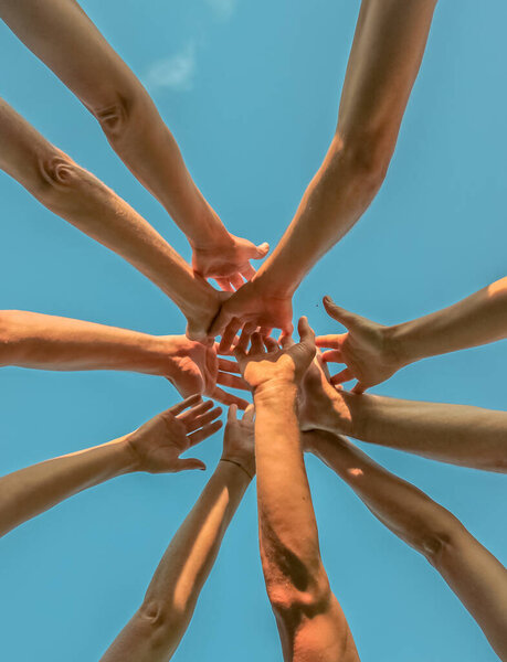 Руки вместе против неба
