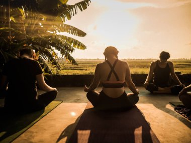 Ubud, Bali, Endonezya - 24 Mayıs 2020: insanlarla gün batımında tropikal açık yoga stüdyosu