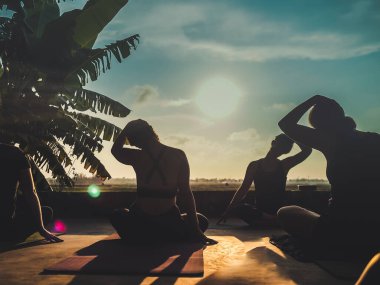 Ubud, Bali, Endonezya - 24 Mayıs 2020: insanlarla gün batımında tropikal açık yoga stüdyosu