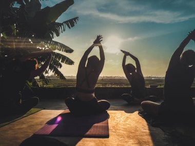 Ubud, Bali, Endonezya - 24 Mayıs 2020: insanlarla gün batımında tropikal açık yoga stüdyosu