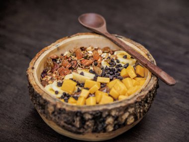 Sağlıklı beslenmek için bir kase yulaf ezmesi, kuru üzüm, fındık, bal ve kuru meyve.