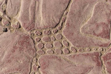 Bir deseni olan kaldırım taşları. Kırmızıya boyanmış beton bir levha. Dış dekorasyon için dekoratif öge.