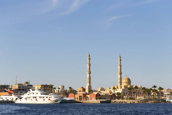 Hurghada, Mısır, gün batımında bir şehir. Kızıl denizden antik şehir manzarası. Panoramik manzara. Gemili bir liman ve camili bir yerleşim yeri..