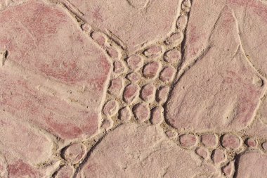 Bir deseni olan kaldırım taşları. Kırmızıya boyanmış beton bir levha. Dış dekorasyon için dekoratif öge.