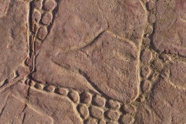 Bir deseni olan kaldırım taşları. Kırmızıya boyanmış beton bir levha. Dış dekorasyon için dekoratif öge.