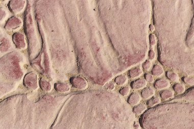 Bir deseni olan kaldırım taşları. Kırmızıya boyanmış beton bir levha. Dış dekorasyon için dekoratif öge.