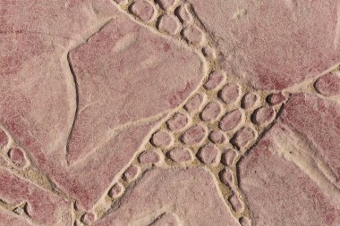 Bir deseni olan kaldırım taşları. Kırmızıya boyanmış beton bir levha. Dış dekorasyon için dekoratif öge.