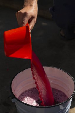 Şarap yapımı. Şarap üreticisi daha ileri işlemler için konteynırdan gerekli olanı alır. Moldova 'da şarap üretim teknolojisi. Üzüm işlemenin eski halk geleneği. Evi hasat et.