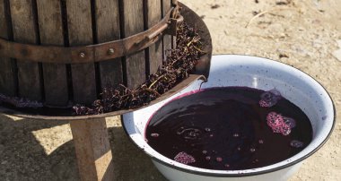 Şarap yapımı. Moldova 'da şarap üretim teknolojisi. Üzüm işlemenin eski halk geleneği. Sıkıştırıcı şarabı bastırmak için kullanılır.. 