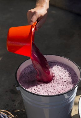 Şarap yapımı. Şarap üreticisi daha ileri işlemler için konteynırdan gerekli olanı alır. Moldova 'da şarap üretim teknolojisi. Üzüm işlemenin eski halk geleneği. Evi hasat et.