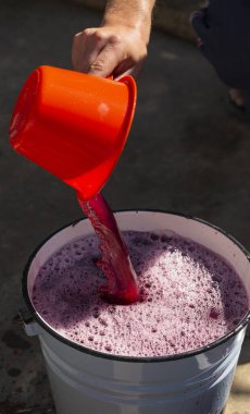 Şarap yapımı. Şarap üreticisi daha ileri işlemler için konteynırdan gerekli olanı alır. Moldova 'da şarap üretim teknolojisi. Üzüm işlemenin eski halk geleneği. Evi hasat et.