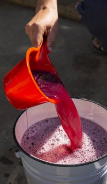 Şarap yapımı. Şarap üreticisi daha ileri işlemler için konteynırdan gerekli olanı alır. Moldova 'da şarap üretim teknolojisi. Üzüm işlemenin eski halk geleneği. Evi hasat et.