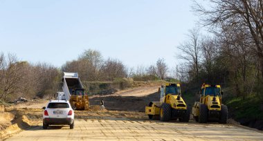 Taraclia, Moldova, 07.04.2020. Yol yapım ekipmanları devrede. Yeni bir yol inşa etmek. Yol servisi otoyolu onarıyor..