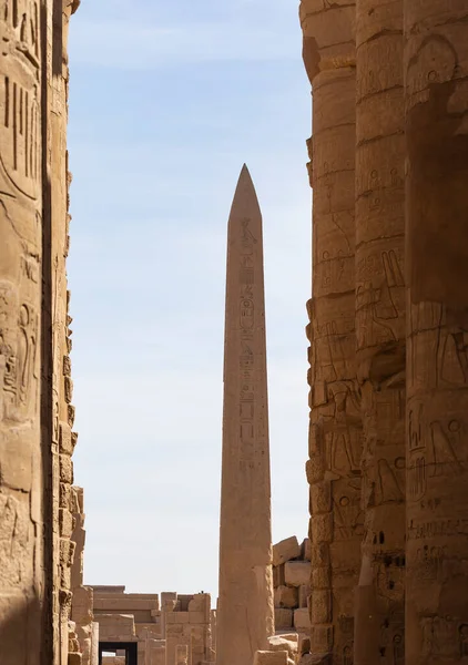 Luxor, Egypt. Karnak Temple, complex of Amun-Re. Embossed hieroglyphics on columns and walls. Tourists visiting the sights. The Obelisk Of Hatshepsut.