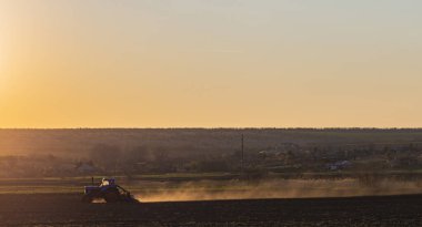 Tohum eken bir traktör tarıma elverişli arazide çalışıyor. Tarım işi. Bahar ekili tahıl..