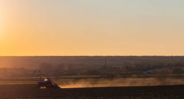 Tractor with a seeder working on arable land. Agricultural work. Spring sowing of grain crops.