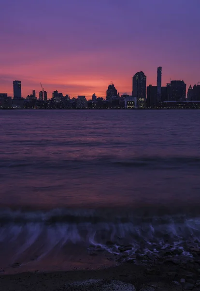 Beautiful sunrise at Hudson River. New York City skyline on the background and Hudson River on the foreground