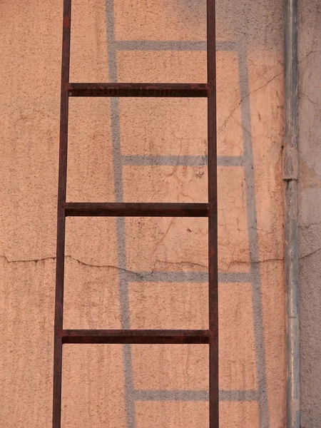 靠在墙上的梯子 朝向一座建筑物的顶部水箱 — 图库照片
