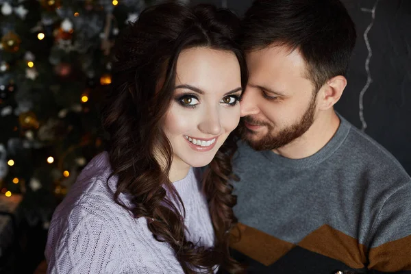 Portrait de couple amoureux, bel homme et jeune beauté passant la soirée de Noël ensemble. Jeune femme et homme élégant jouissant de relations parfaites et passer la veille de la nouvelle année dans un intérieur confortable — Photo