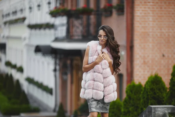 Prise de vue de mode de belle fille élégante portant des lunettes de soleil et gilet de fourrure. Jeune femme en tenue modish en plein air dans la rue. Une inspiration shopping. Concept de style de vie de luxe. Style de vie de luxe attributs — Photo