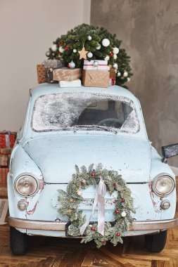 Noel süslemeli klasik araba. Yeni yıl tatili için dekore edilmiş, bayram hediyeleriyle dolu klasik bir araba. Noel ağacı ve hediyelerle süslenmiş eski bir Noel arabası