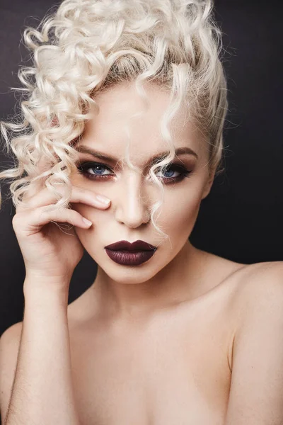 Ausgeschnittenes Porträt einer jungen Frau mit hellem Make-up, blauen Augen und lockigem blonden Haar. Modelmädchen mit dunklen vollen Lippen, perfekter glatter Haut und sinnlichem Gesichtsausdruck — Stockfoto