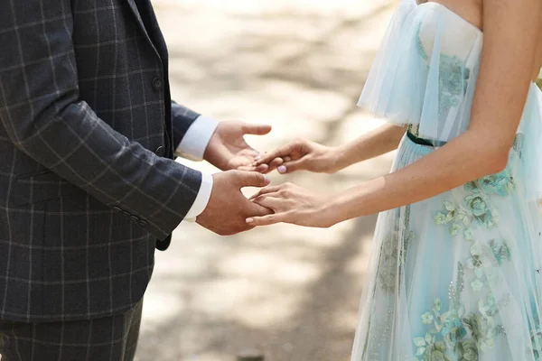 Close view of male and female hands. Young businessman holding hands of a young woman. Closeup cropped photo of two young lovers holding hands. Handsome groom holding hands of a young bride. — Stockfoto