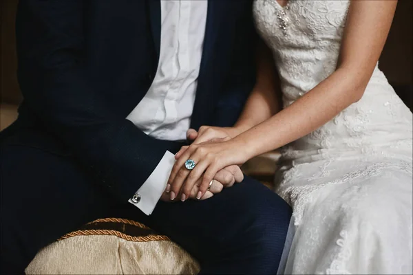 Detailně oříznuté fotografie mužských a ženských rukou s drahými snubními prsteny. Mužské ruce drží krásné ženské ruce s roztomilou manikúrou a drahý zlatý prsten s velkým diamantem — Stock fotografie