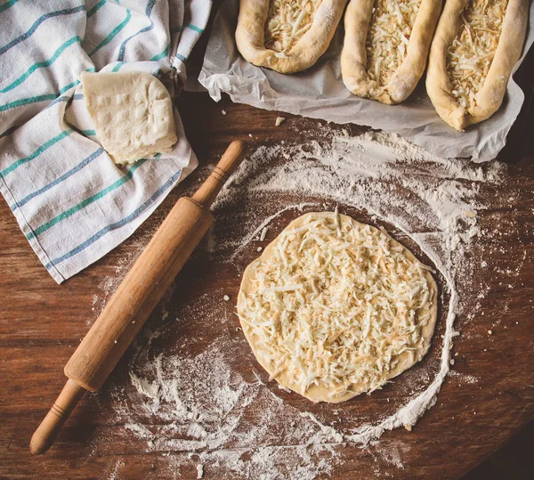 Cocinar khachapuri con queso en una mesa —  Fotos de Stock