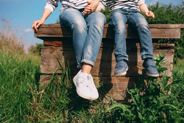 Mamma och barn sitter på kanten av en gammal trä väl — Stockfoto