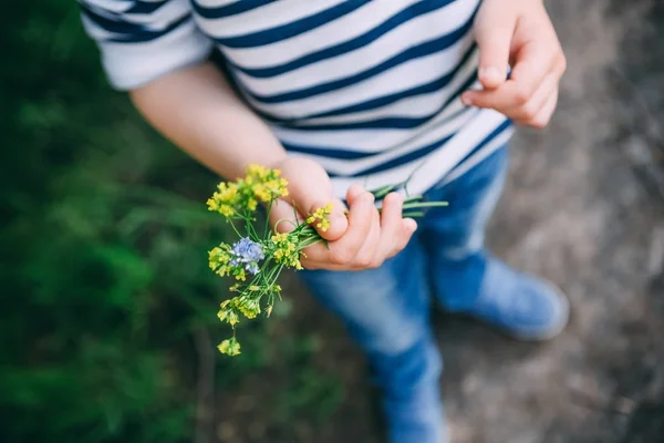 Bir buket çiçekler elinde tutan küçük bir çocuk — Stok fotoğraf