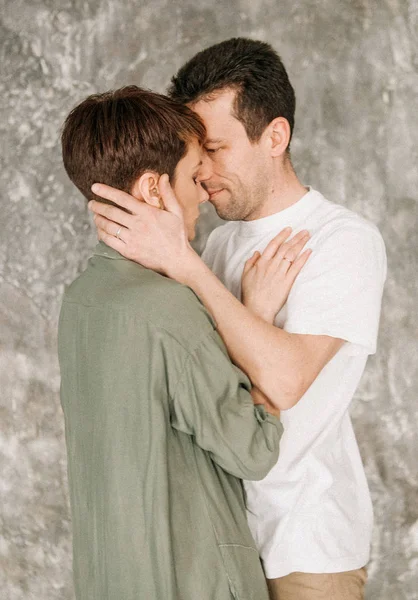 Amante pareja abraza fondo gris — Foto de Stock