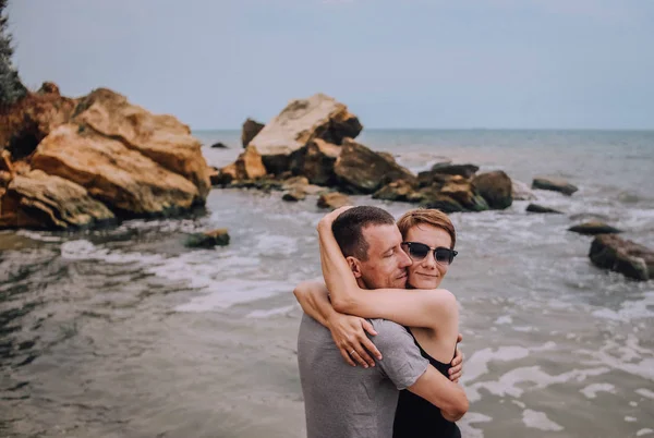 Pasangan cinta pelukan terhadap batu besar laut — Stok Foto