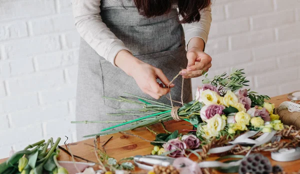 Florista mujer recoge ramo decora diferentes flores — Foto de Stock