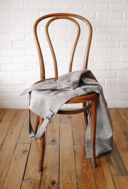 odanın ortasına bir koltuğu üzerinde gri önlük yalan