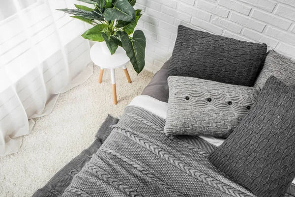 Dormitorio cama interior en tonos grises con flores en la mesita de noche —  Fotos de Stock