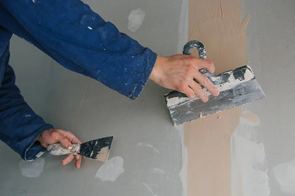 Obras de gesso reboco duas espátulas gesso placa azul uniforme — Fotografia de Stock