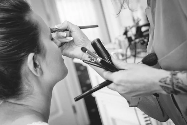Vrouw doen ochtend make-up kwasten holding vulpotloden handen — Stockfoto