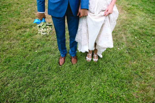 Brudgummen bruden soliga ängen kostym klänning blommor — Stockfoto