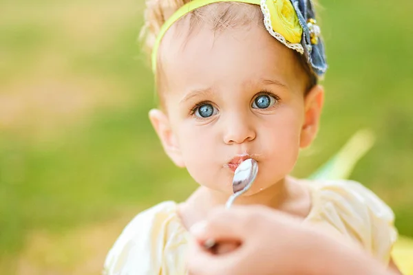 小さな青い目の少女を食べる外遊び — ストック写真