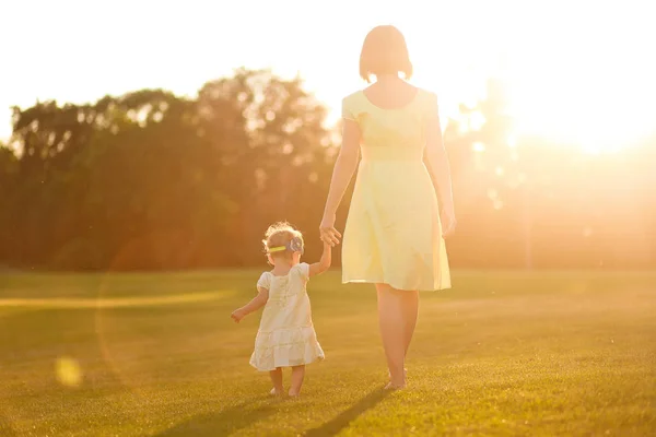 Máma a dcera šaty bosý nohy ruce travní západ slunce — Stock fotografie